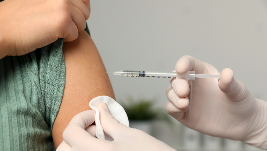 Close shot of physician giving patient a shot in the arm